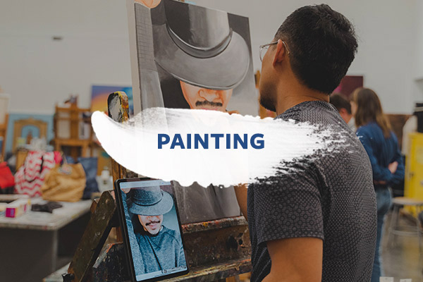 Person painting in class: From the fundamentals to advanced techniques, our painting classes cover a broad range of media and subjects.